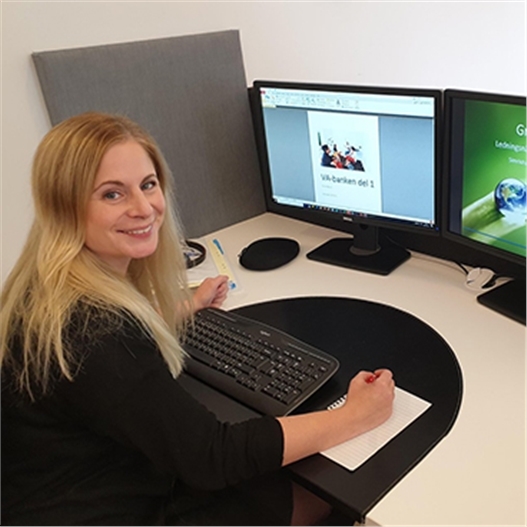 Sofie Backö sitter vid datorn och tittar in i kameran.